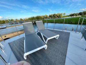 two chairs sitting on the deck of a boat at Huisboot Comfort M Plus Limburg in Kinrooi