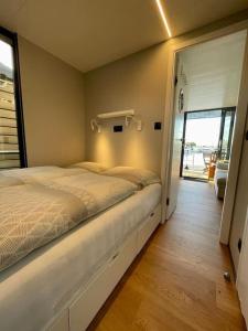 a bedroom with a bed and a sliding glass door at Huisboot Comfort M Plus Limburg in Kinrooi
