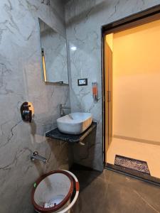 a bathroom with a sink and a toilet and a mirror at Sharan Residency in Navi Mumbai +29 photos