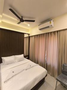 a bedroom with a bed and a ceiling fan at Sharan Residency in Navi Mumbai