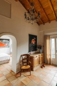 a bedroom with a bed and a chair and a chandelier at Apricus Locanda Boutique Hotel in Apricale