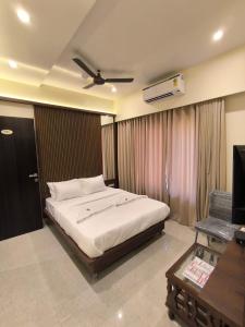a bedroom with a bed with a ceiling fan at Sharan Residency in Navi Mumbai
