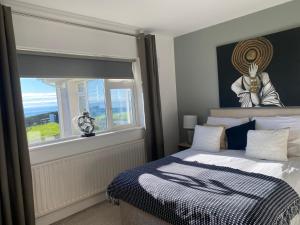 a bedroom with a bed and a large window at Follies Suites Ballyvoile in Dungarvan