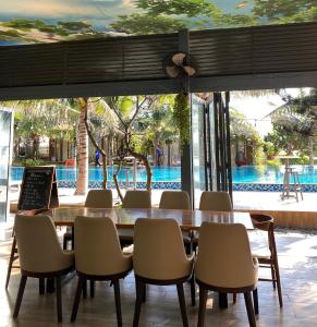 a dining room with a table and chairs and a pool at An Hoa Residence in Long Hai