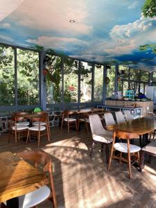 un restaurante con mesas y sillas de madera y ventanas en An Hoa Residence, en Long Hai