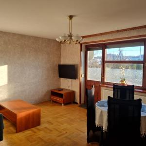 uma sala de estar com uma mesa e uma televisão em WILLA MIŁA em Stalowa Wola