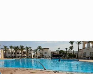 een zwembad in een resort met palmbomen en gebouwen bij New house in Sharm El Sheikh