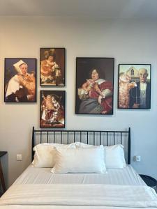 a bedroom with pictures of people on the wall at Linnea 2R1B Nordic inspired theme at Jesselton Quay in Kota Kinabalu