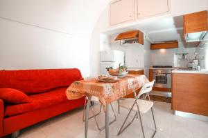 a living room with a red couch and a table at Minuta Skyline Pontone Holiday house in Pontone
