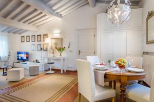 uma sala de estar com uma mesa e uma sala de jantar em Casa Santa Zita, A Toproof Penthouse Apartment with Elevator and Private Garden Inside the Walls em Lucca