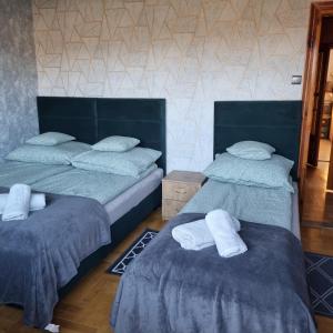 dwa łóżka z ręcznikami na nich w pokoju w obiekcie WILLA MIŁA w mieście Stalowa Wola
