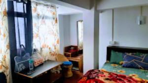 a bedroom with a bed and a large mirror at Riva Homestay and Restaurant , Darjeeling in Darjeeling