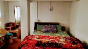 a bedroom with a bed with a colorful comforter at Riva Homestay and Restaurant , Darjeeling in Darjeeling