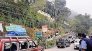 a group of cars driving down a road at Riva Homestay and Restaurant , Darjeeling in Darjeeling