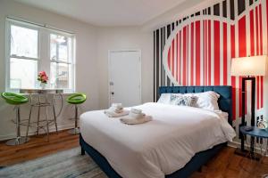 1 dormitorio con 1 cama grande y pared de rayas rojas y blancas en French design Luxurious Downtown 3br/2ba that sleeps 8 guests with Optional Valet Parking en Chicago