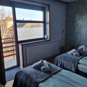 a room with two beds and a large window at WILLA MIŁA in Stalowa Wola