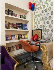 a living room with a chair and a desk with a book shelf at Suite with an airy rooms in Kānpur