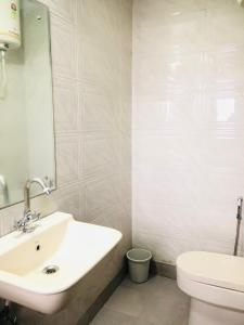 a bathroom with a sink and a toilet and a mirror at 2BHK Independent Service Apart with Lift in Vasant Kunj New Delhi in New Delhi