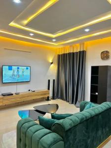 ein Wohnzimmer mit einem Sofa und einem Flachbild-TV in der Unterkunft Timba ciné01 in Cotonou