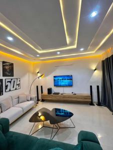 ein Wohnzimmer mit einem Sofa und einem TV in der Unterkunft Timba ciné01 in Cotonou