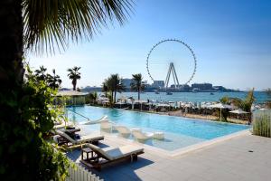 ein Schwimmbad mit einem Riesenrad im Hintergrund in der Unterkunft Luxury apartments at La Vie in Dubai