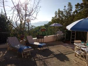 a patio with chairs and tables and an umbrella at Apartment with pool Aircon & mountain views in Gallinaro