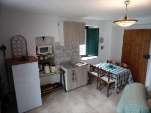 a kitchen with a sink and a table with a microwave at Apartment with pool Aircon & mountain views in Gallinaro