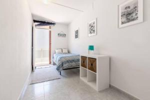 - une chambre blanche avec un lit et une fenêtre dans l'établissement Agradable apartamento justo en la playa, à Castelldefels