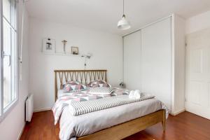 - une chambre blanche avec un grand lit et des oreillers dans l'établissement Chic apart with terrace and parking, à Bobigny