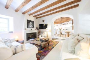 a living room with white furniture and a fireplace at ES CLOT in Deia