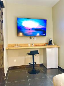 a desk with a television on a wall with a stool at L'Eskale Guyane in Montjoly