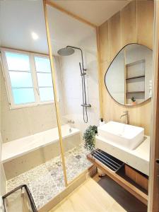 La salle de bains est pourvue d'un lavabo et d'un miroir. dans l'établissement Le Cocon Design - Gare / Centre ville de Caen, à Caen