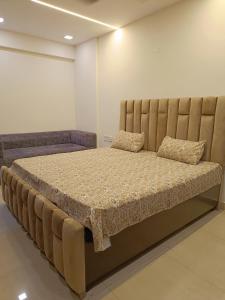 ein großes Bett mit einem großen Kopfteil in einem Zimmer in der Unterkunft Luxury Furnish Studio Apt 623 in DLF Moti Nagar Delhi in Neu-Delhi