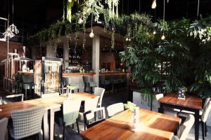 ein Restaurant mit Holztischen, Stühlen und Pflanzen in der Unterkunft FOLGA - Hotel, Restauracja, Browar, SPA in Gryfice