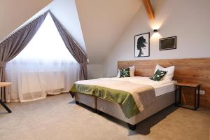 a bedroom with a bed and a large window at FOLGA - Hotel, Restauracja, Browar, SPA in Gryfice