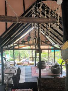 a room with a wooden ceiling with a chandelier at Thip Bungalow in Ko Tao