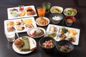 una tavola ricoperta di piatti e ciotole di cibo di KOKO HOTEL Sendai Kotodai Park a Sendai