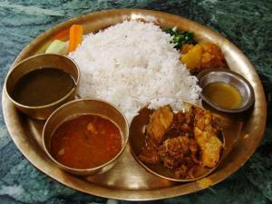 a plate of food with rice and different types of food at Sparrow Nest Homestay in Darjeeling