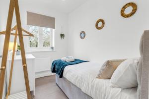 a white bedroom with a bed and a window at Lark Rise Lodge in Brackley