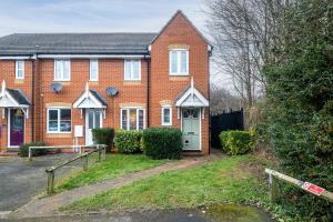 a brick house with a gate in front of it at Lark Rise Lodge in Brackley