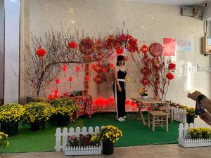 a woman standing in front of a room with red decorations at COZY Hotel HCM in Ho Chi Minh City