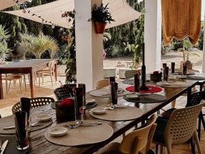 een lange houten tafel met stoelen en een tafel met borden bij Hotel Finca Duende - Adults Only in Hozanejos