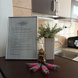 a teddy bear sitting on a kitchen counter with a sign at Apartament Florina in Râmnicu Vâlcea