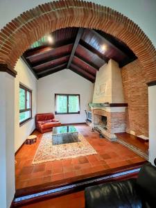 un grand salon avec une cheminée en briques dans l'établissement Chalet con piscina climatizada., 