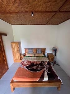 - une chambre avec un grand lit dans l'établissement Green Haven Homestay, à Tetebatu