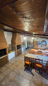 una sala da pranzo con tavoli e sedie e una cucina di Complejo Raíces Patagonicas a Dina Huapi