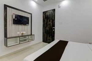 a bedroom with a bed and a flat screen tv at OYO Flagship THE VINDH in Gorakhpur