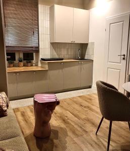 a kitchen with a stool in the middle of a room at Sands Sopot Apartments in Sopot