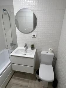 a white bathroom with a sink and a mirror at Sunny Apartments Avanera Suceava in Suceava +25 photos