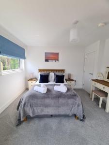 a bedroom with a large bed with two pillows at BayVue Apartment & Apartment 7, The Bay House in Shanklin